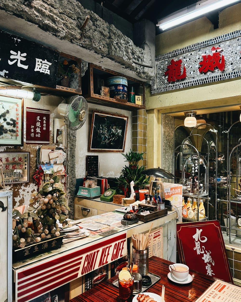 The shop counter, with an old ceiling fan, framed notices and stacked tins