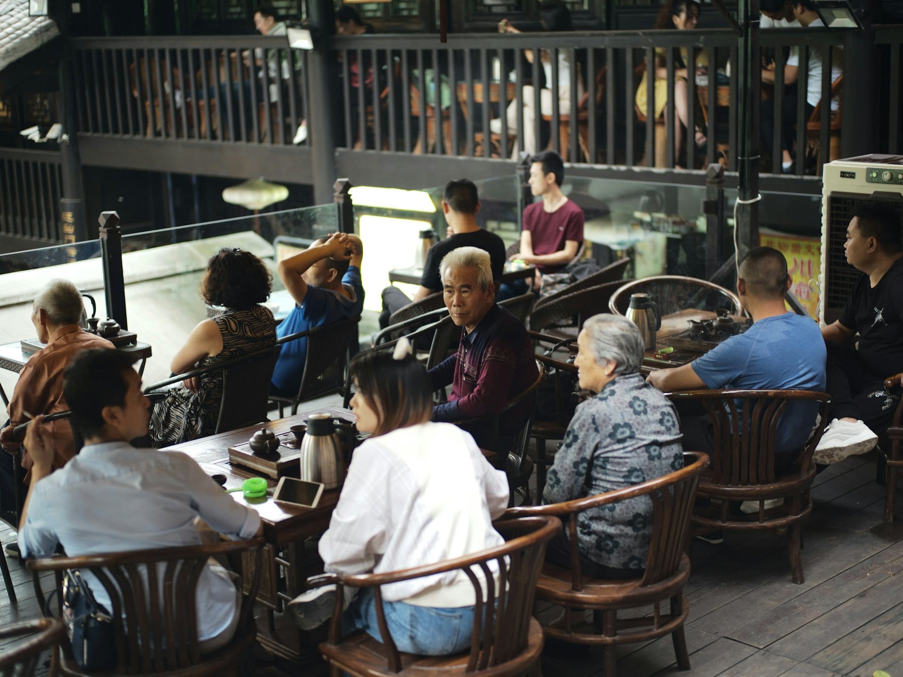 Customers at wooden tables in a busy old-style coffee shop