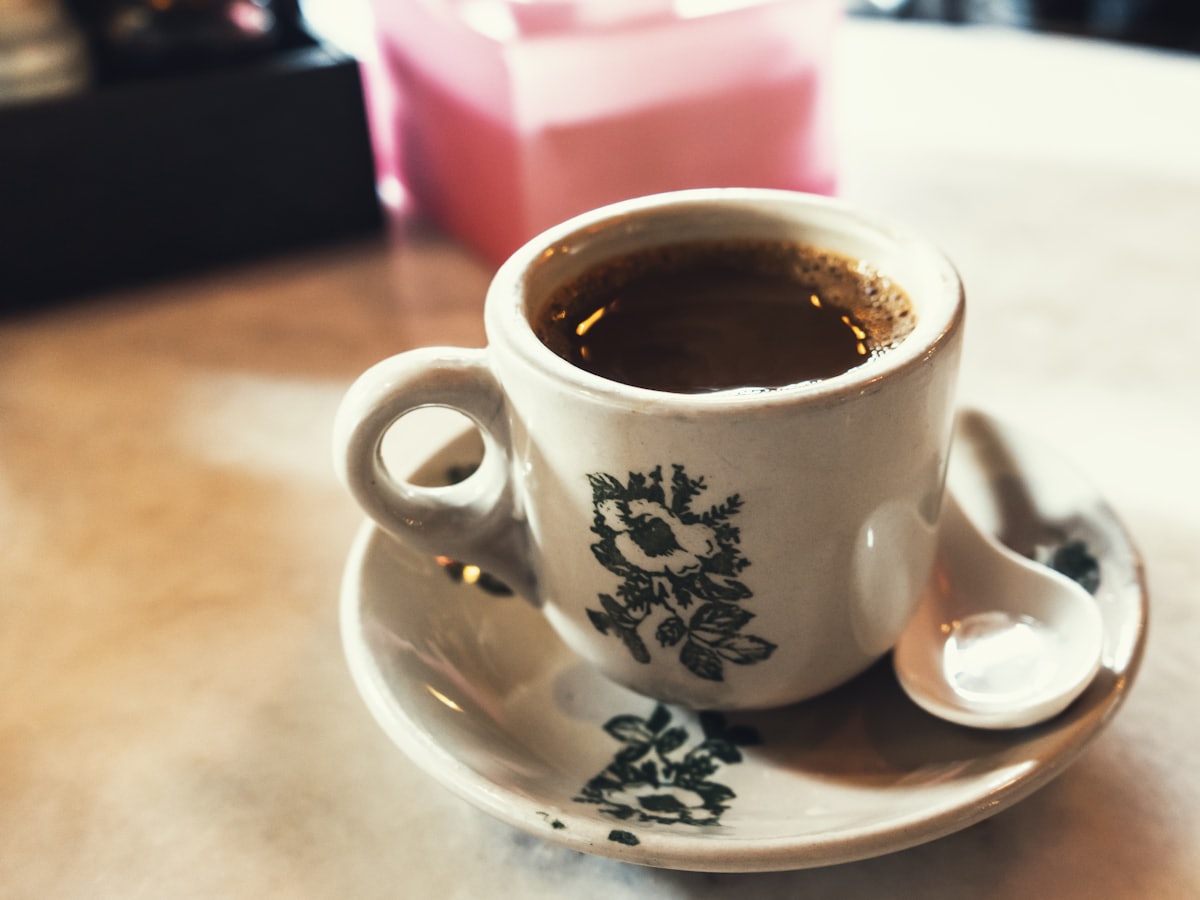 A ceramic mug of white coffee on a saucer